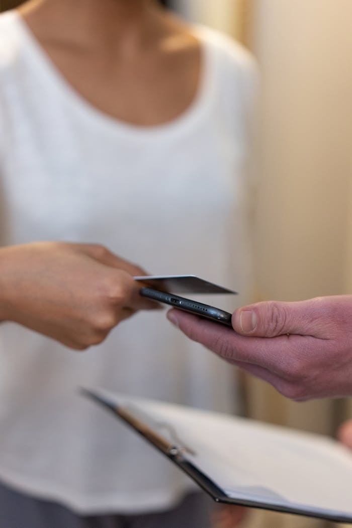 A person hands over a credit card for payment, illustrating a financial transaction.